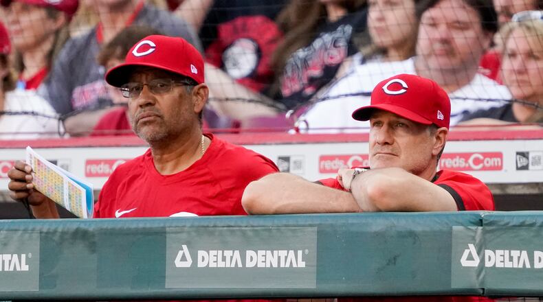 Cincinnati Reds manager David Bell, right, stands in the dugout with bench coach Freddie Benavides during the sixth inning of a baseball game against the St. Louis Cardinals Saturday, April 23, 2022, in Cincinnati. (AP Photo/Jeff Dean)