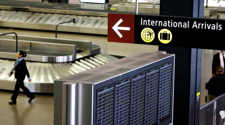 FILE - In this June 26, 2017, file photo, a sign for International Arrivals is displayed at the Seattle-Tacoma International Airport in Seattle. Beginning next week, the federal government plans to end the current system of temperature checks and travelers vouching for the health. Instead, the Centers for Disease Control and Prevention say they will focus on other measures including stronger reporting of illness at airports. The enhanced screening currently applies to people who have recently been in China, Iran, most European countries, the U.K., Ireland and Brazil. (AP Photo/Ted S. Warren, File)
