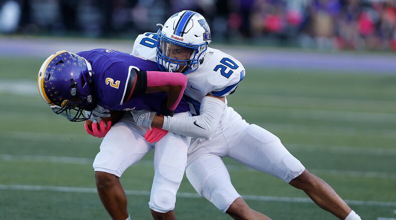 Butler's Tayven Crump is tackled by Xenia's Trimonde Henry after catching a pass. BILL LACKEY/STAFF