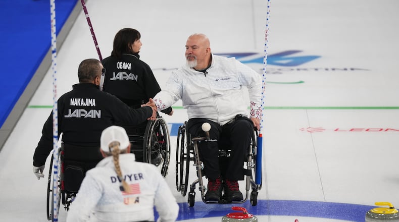 Steve Emt, right, and Laura Dwyer, of the United States, and Yoji Nakajima, left, and Aki Ogawa, of Japan, greet each other after their wheelchair curling mixed doubles round robin session at the 2026 Winter Paralympics, in Cortina d'Ampezzo, Italy, Thursday, March 5, 2026. (AP Photo/Evgeniy Maloletka)