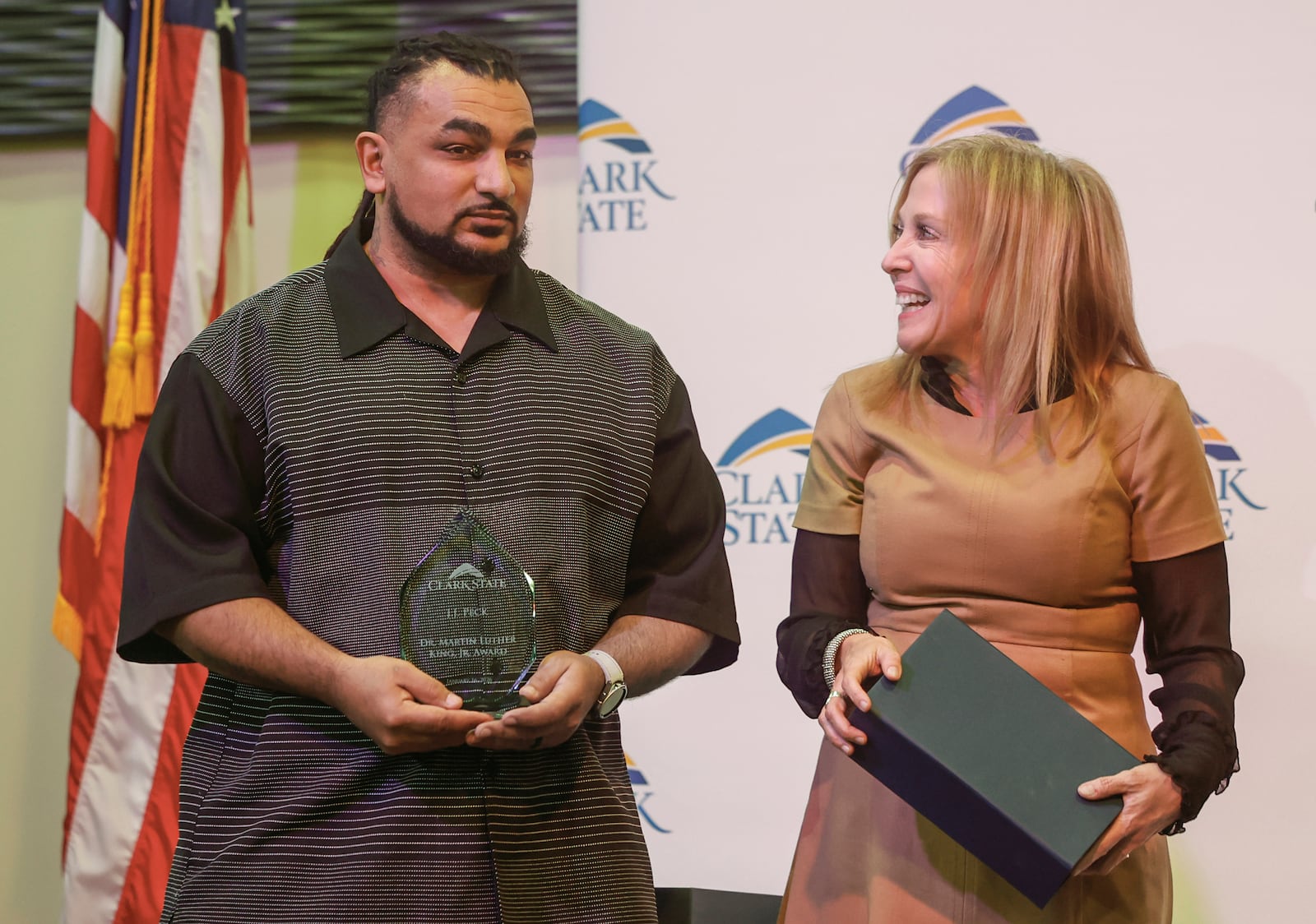 J.J. Peck, left, coordinator of the Peer Recovery Support program at Clark State College, receives the Martin Luther King, Jr. Award from Clark State President Jo Alice Blondin at Clark State's annual MLK luncheon and awards ceremony at the Hollenbeck Bayley Center on Friday, Jan. 16, 2026, in Springfield. JOSEPH COOKE/STAFF
