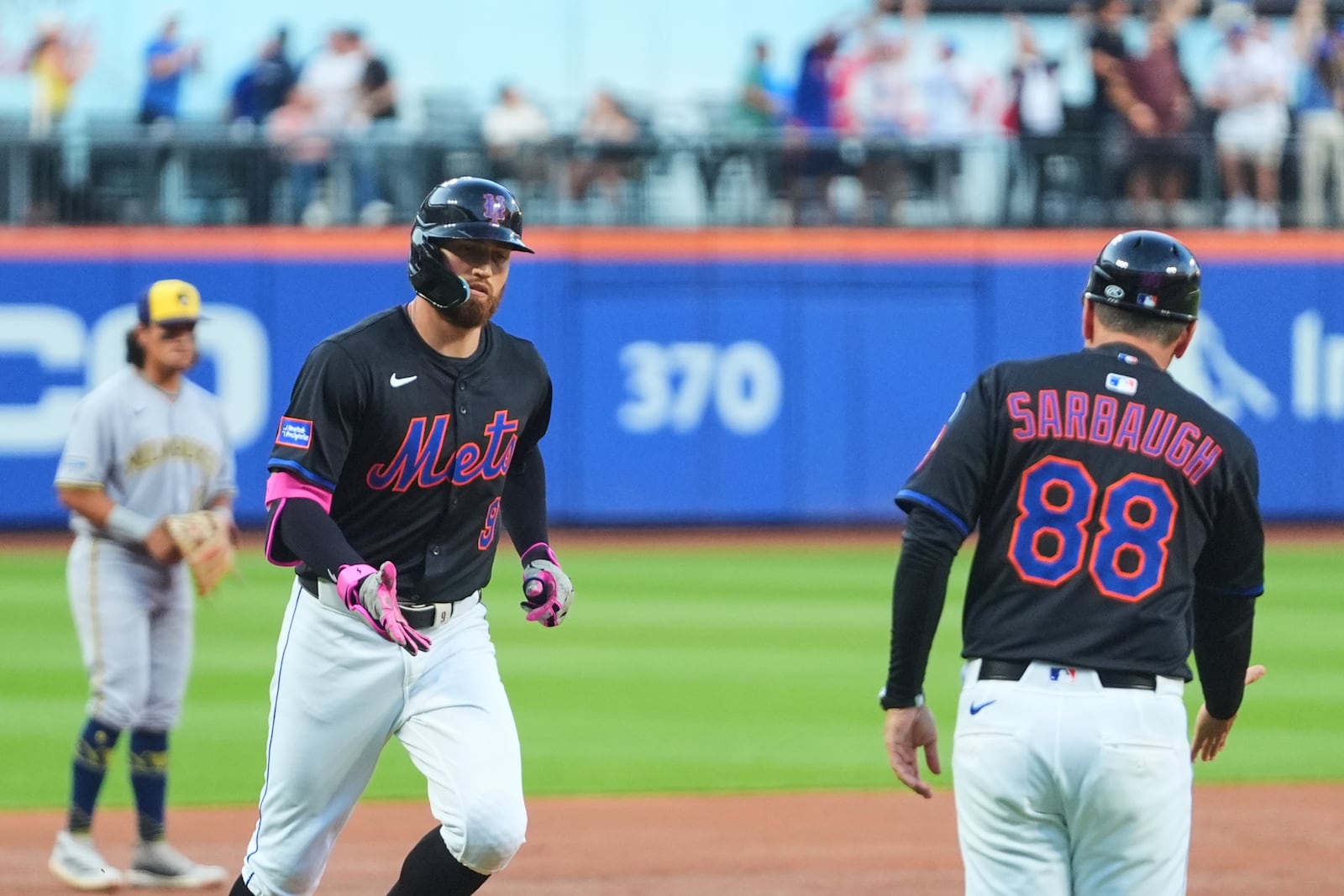 New York Mets' Brandon Nimmo (9) celebrates with third base coach Mike Sarbaugh (88) as he runs the bases after hitting a grand slam during the second inning in the second baseball game of a doubleheader Wednesday, July 2, 2025, in New York. (AP Photo/Frank Franklin II)