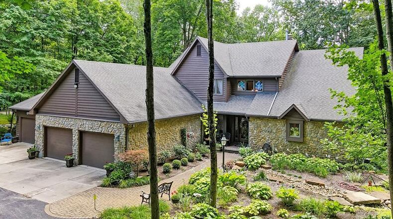 The front of the home has a four car attached garage and stone and cedar exterior as well as professional landscaping.