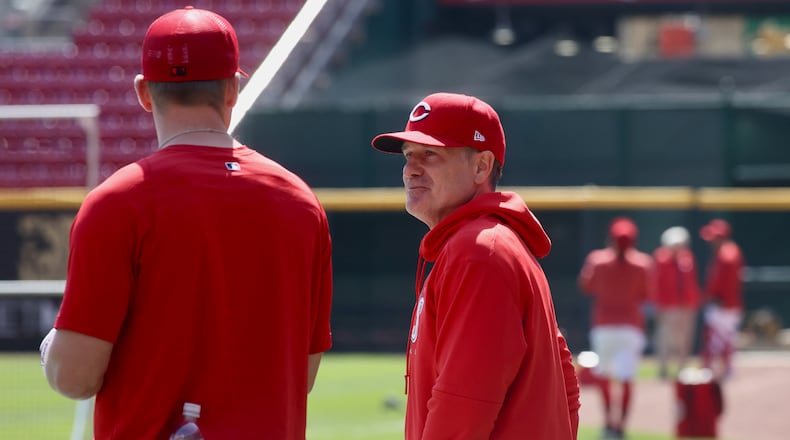 Reds manager David Bell, right, talks to Tyler Stephenson during batting practice on Opening Day on Thursday, March 30, 2023, at Great American Ball Park in Cincinnati. David Jablonski/Staff