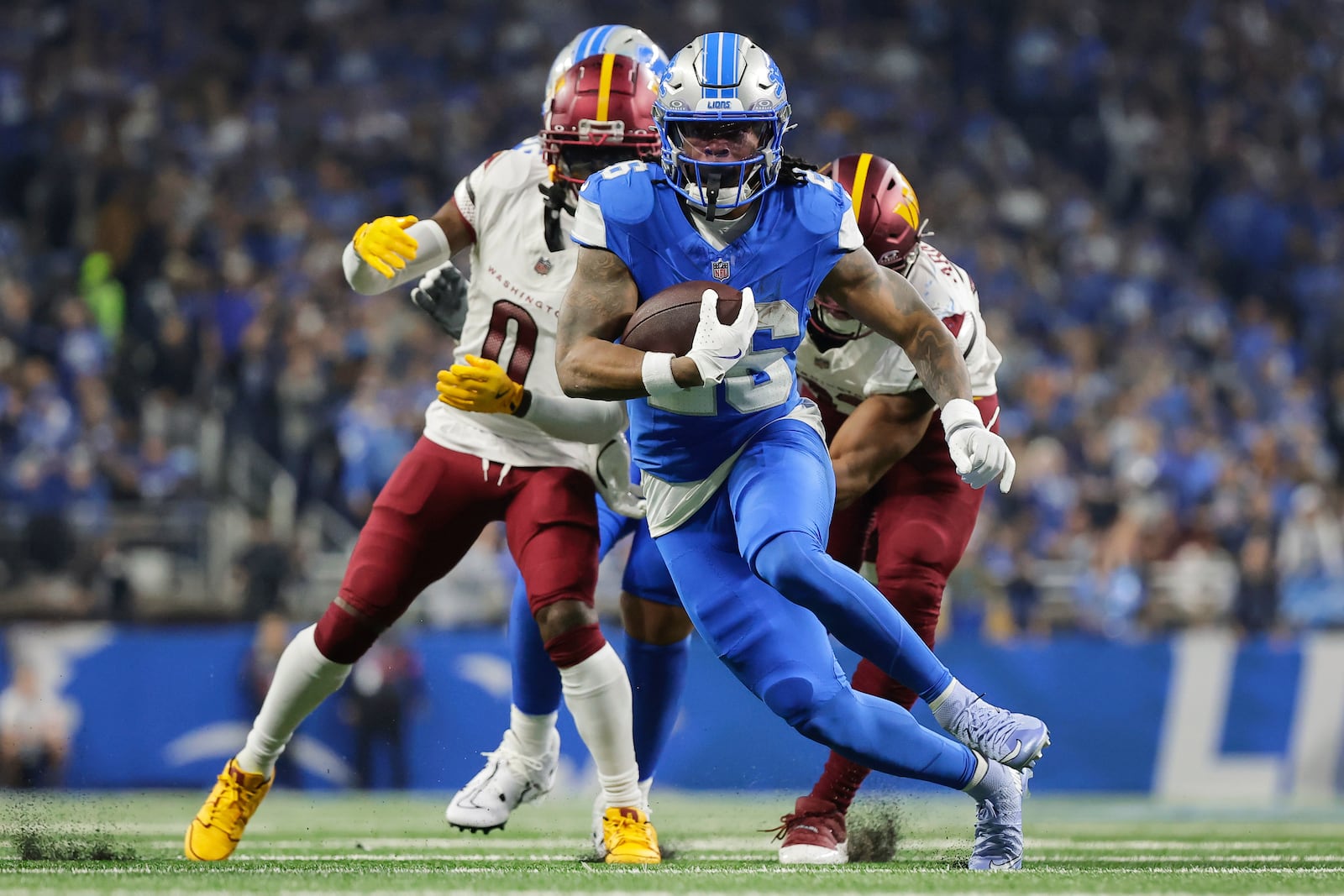 FILE - Detroit Lions running back Jahmyr Gibbs (26) runs past Washington Commanders cornerback Mike Sainristil (0) during the first half of an NFL football divisional playoff game, Saturday, Jan. 18, 2025, in Detroit. (AP Photo/Rey Del Rio, File)