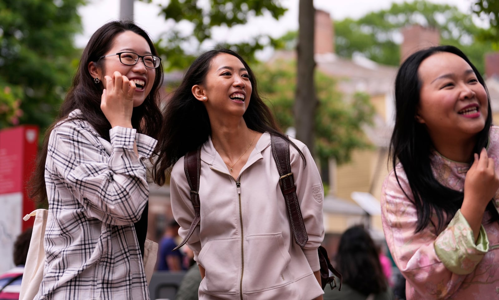 Yurong "Luanna" Jiang, center, who delivered a speech at her Harvard University commencement, jokes with her college friends Helen Ji, left, and Cynthia Luo, Friday, May 30, 2025, in Cambridge, Mass. (AP Photo/Charles Krupa)