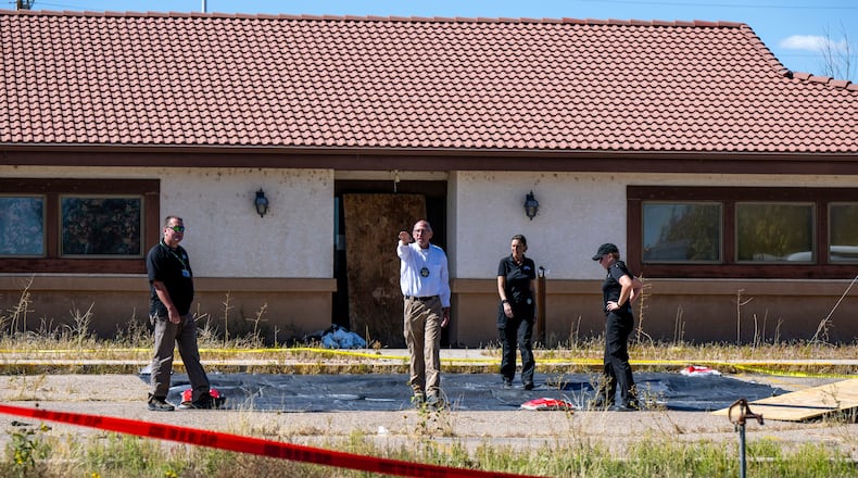 FILE - Fremont County coroner Randy Keller, center, and other authorities survey the area where they plan to put up tents at the Return to Nature Funeral Home where over 100 bodies have been improperly stored, Saturday, Oct. 7, 2023, in Penrose, Colo. (Parker Seibold/The Gazette via AP, File)