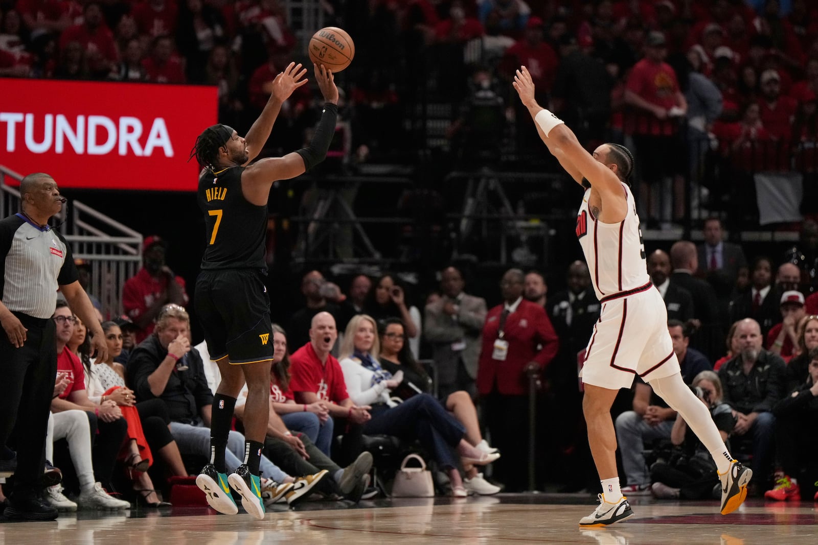 Golden State Warriors' Buddy Hield (7) shoots a three-pointer as Houston Rockets' Dillon Brooks (9) defends during the first half of Game 7 of an NBA basketball first-round playoff series Sunday, May 4, 2025, in Houston. (AP Photo/Ashley Landis)