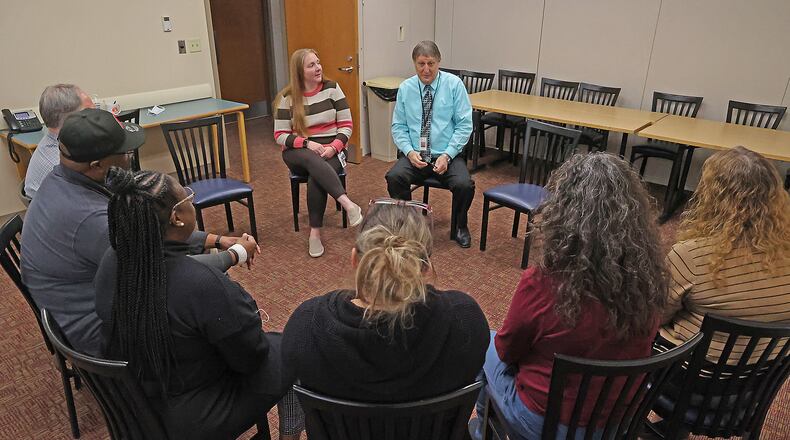 Erin Foster and Andrew Lohrer, both from Mental Health Services of Clark and Madison County, hold a group session with people Tuesday at the Mental Health Services building on North Yellow Springs Street. BILL LACKEY/STAFF