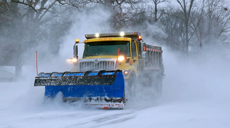 A Clark County snow plow cleans off Dayton Road between Springfield and Enon Friday, Dec. 23, 2022. BILL LACKEY/STAFF