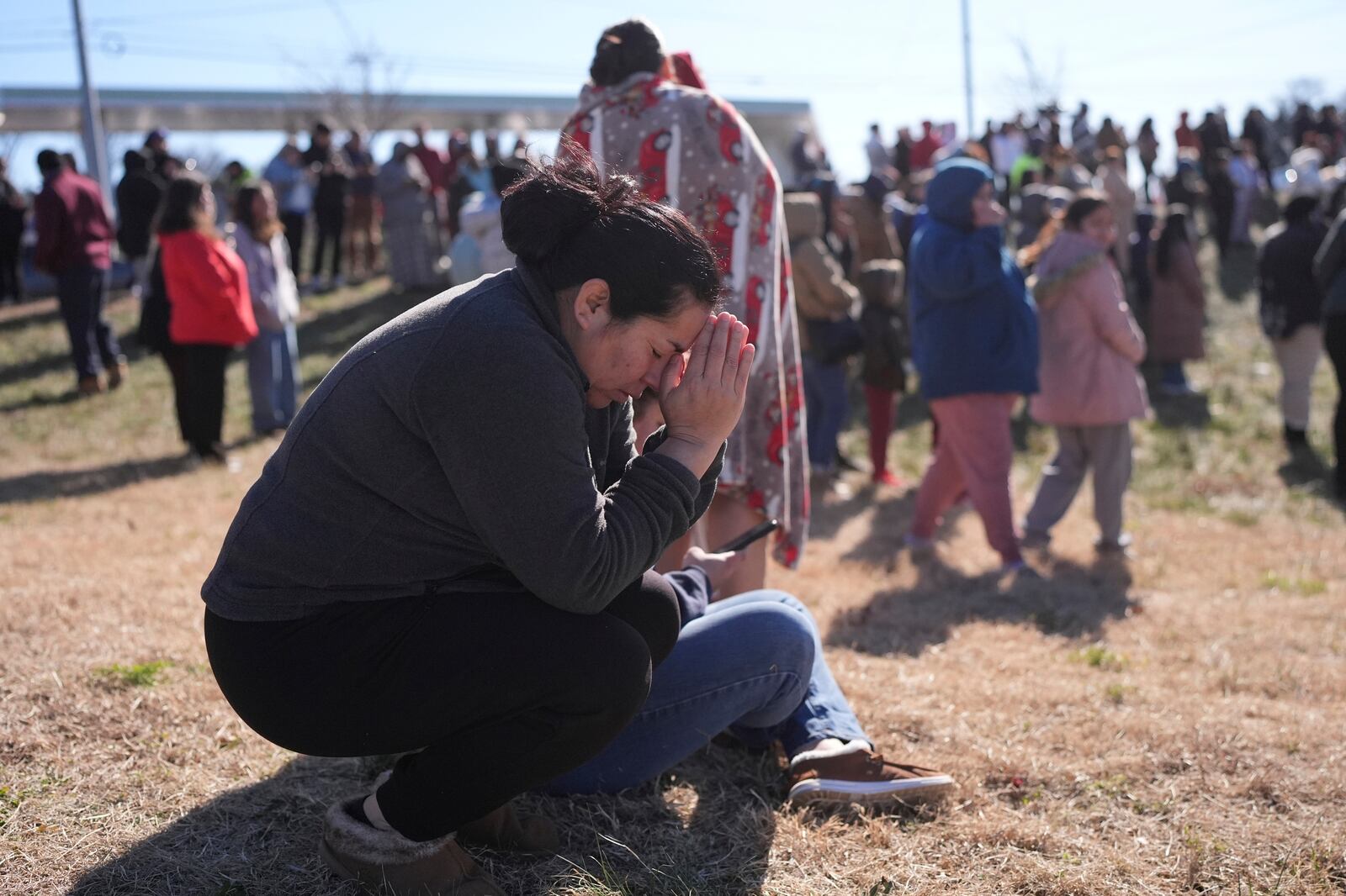 FILE -Dasia Pleitez prays as she waits for her daughter at a unification site following a shooting at the Antioch High School in Nashville, Tenn., Wednesday, Jan. 22, 2025. (AP Photo/George Walker IV, File)