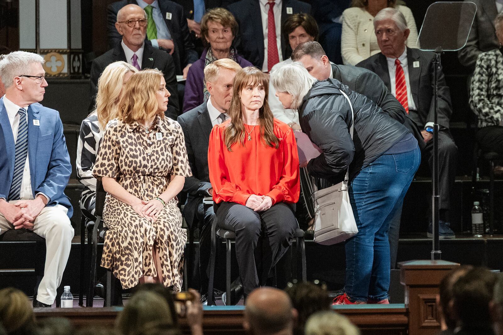 A woman gets onto the stage to speak to U.S. Senator James Lankford before being escorted away during the 30th anniversary memorial service for the victims of the 1995 Oklahoma City bombing, in Oklahoma City, Saturday, April 19, 2025. (AP Photo/Alonzo Adams)