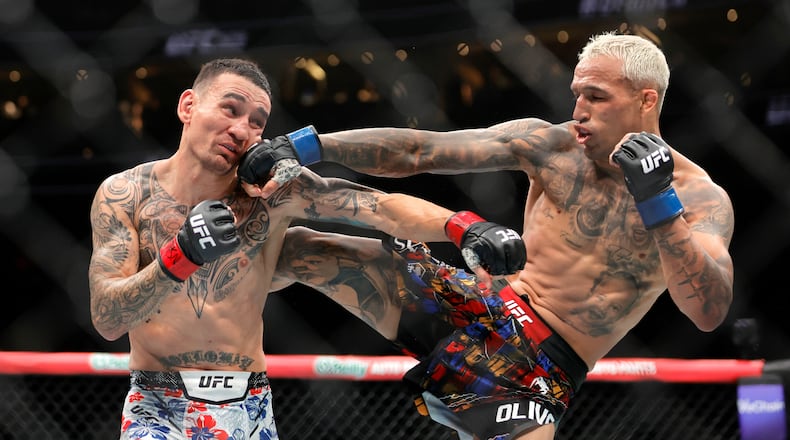 Charles Oliveira, right, punches Max Holloway in a lightweight fight during UFC 326 Saturday, March 7, 2026, in Las Vegas. (Steve Marcus/Las Vegas Sun via AP)/Las Vegas Sun via AP)