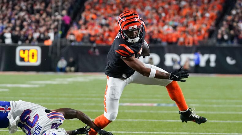 Cincinnati Bengals wide receiver Ja'Marr Chase, right, tries to dodge a tackle attempt by Buffalo Bills cornerback Dane Jackson during the first half of an NFL football game, Sunday, Nov. 5, 2023, in Cincinnati. (AP Photo/Darron Cummings)
