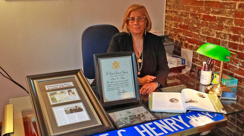 Lisa Henry, the daughter of Robert C. Henry, with some of the historic items she's going to have preserved in the Heritage Center's collection event Wednesday. BILL LACKEY/STAFF