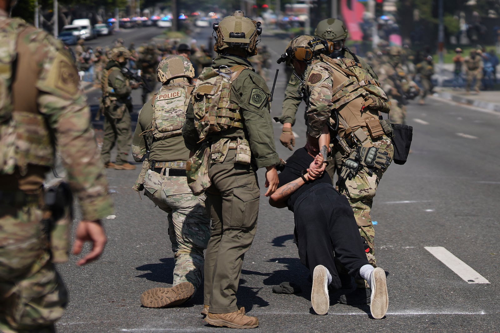 Police detain a man during a protest in the Paramount section of Los Angeles, Saturday, June 7, 2025, after federal immigration authorities conducted operations. (AP Photo/Eric Thayer)