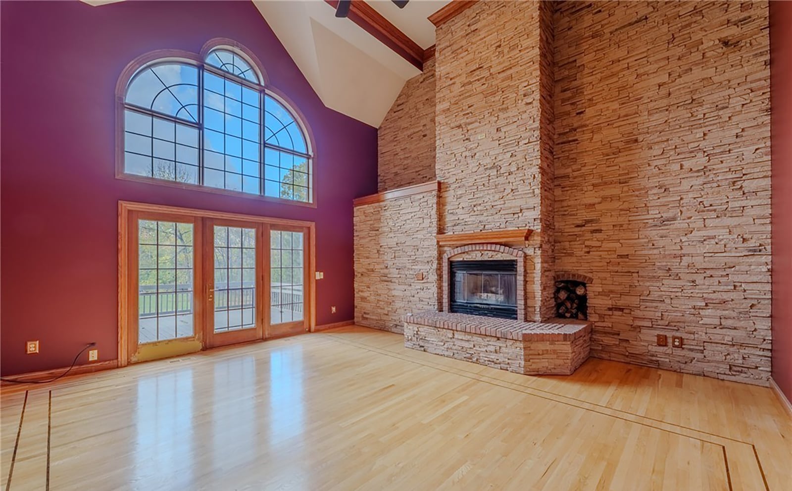The two story living room has hardwood floors, a floor to ceiling stacked stone fireplace with a full accent wall, beamed ceiling and ceiling fan. Exterior doors open to the raised backyard deck. CONTRIBUTED