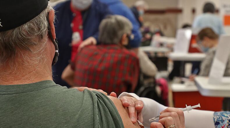Clark County residents get their COVID vaccine shots at the Clark County Combined Health District's vaccine distribution center at the Upper Valley Mall Tuesday. BILL LACKEY/STAFF