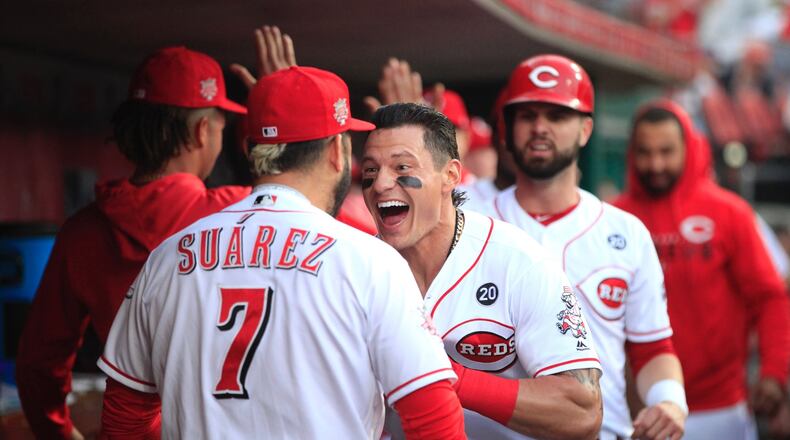 The Reds’ Derek Dietrich celebrates with Eugenio Suarez after hitting a three-run home run against the Giants on Friday, May 3, 2019, at Great American Ball Park in Cincinnati. David Jablonski/Staff