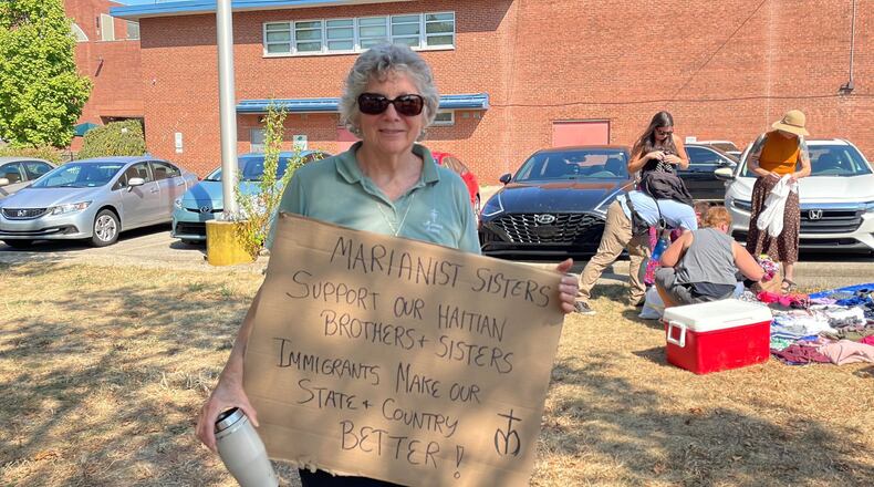 An attendee of a Dayton rally in support of Haitian Springfield residents on Sunday held a sign in support of immigrants.