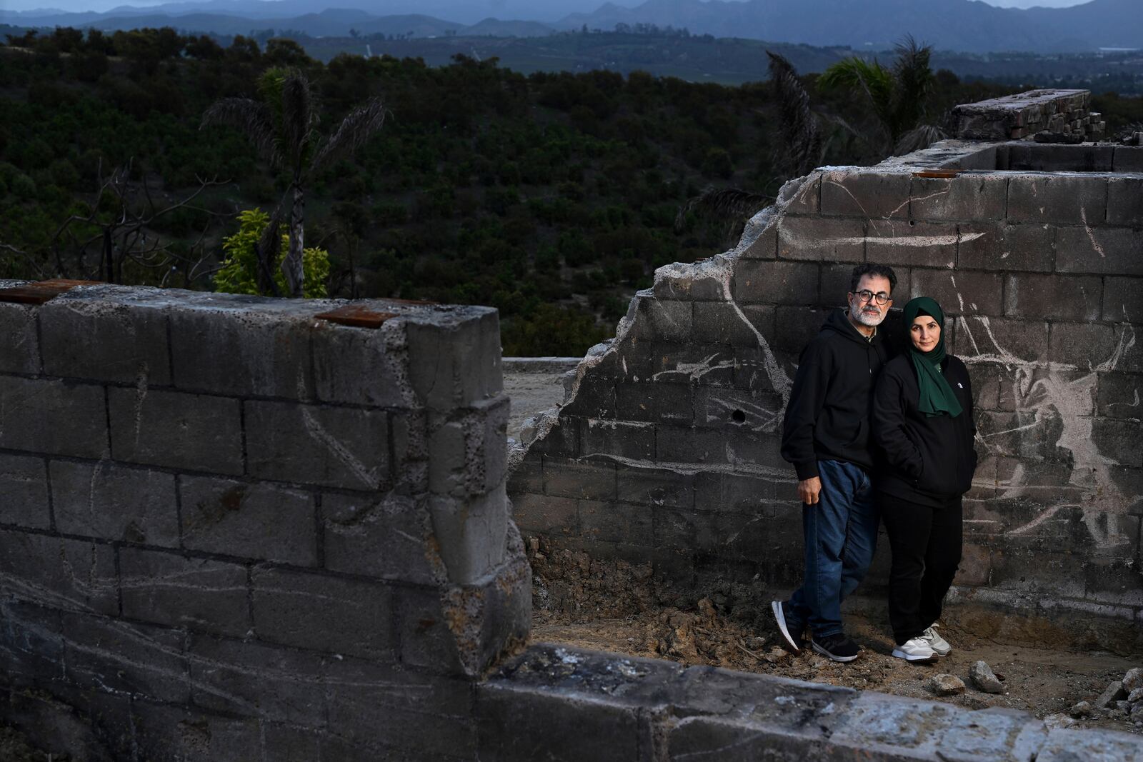 Hatim Naim and his wife Samah stand in a shell of what was their house after it burned in the Mountain Fire Wednesday, April 16, 2025, in Somis, Calif. (AP Photo/Wally Skalij)