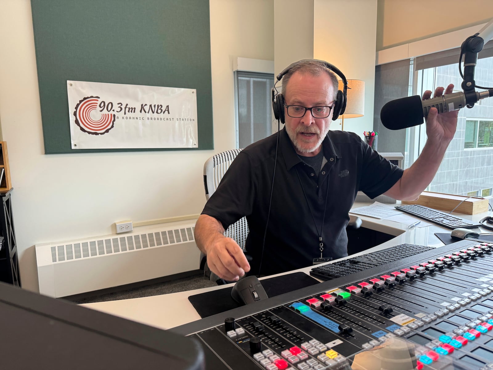 Loren Dixon, the director of programming at KNBA, the flagship station for National Native News and owned by Koahnic Broadcast Corp., is shown on air July 10, 2025, at the station's studios in Anchorage, Alaska. (AP Photo/Mark Thiessen)