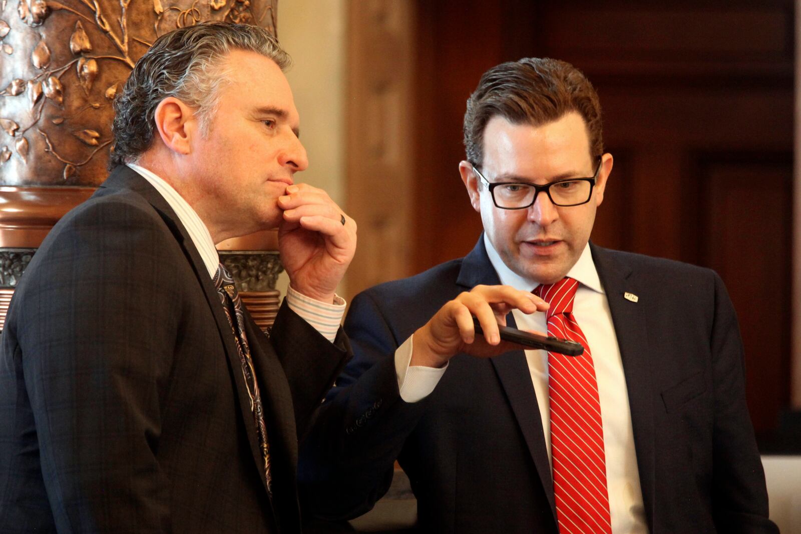 Kansas Senate President Ty Masterson, left, R-Andover, confers with Sen. J.R. Claeys, right, R-Salina, during the Senate's debate on a bill that would eliminate the extra three days after Election Day that voters have to return their mail ballots, Tuesday, March 25, 2025, at the Statehouse in Topeka, Kan. (AP Photo/John Hanna)