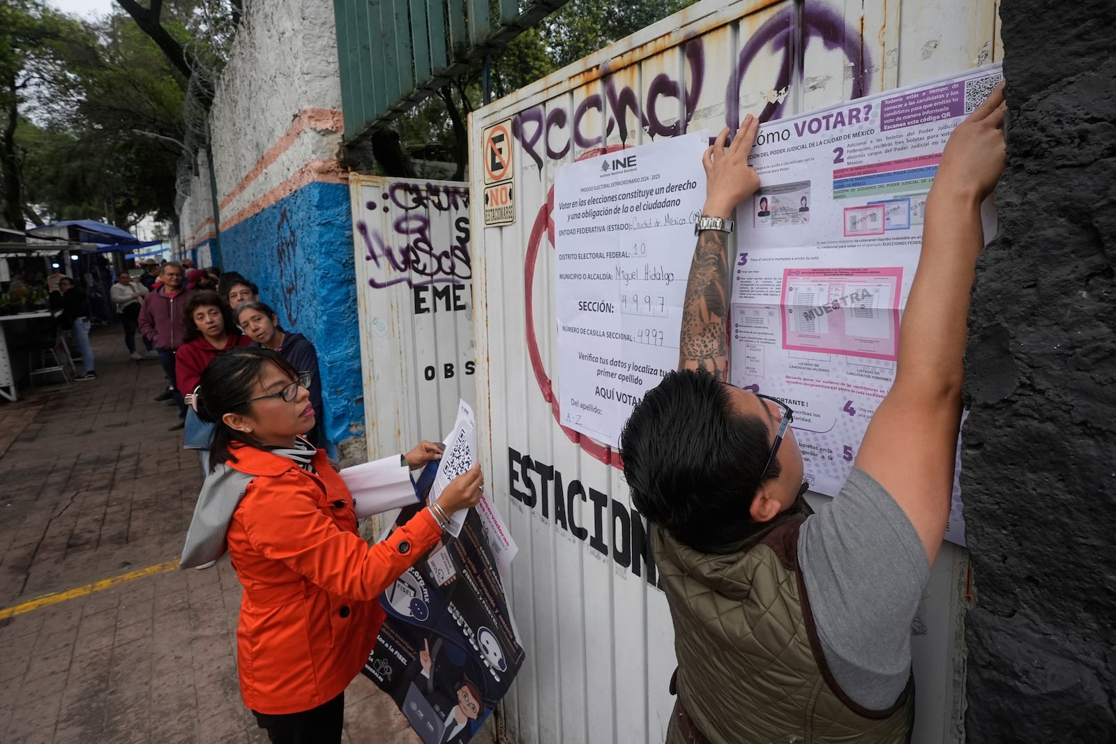Electoral workers fix signs at a polling station during the country's first judicial elections in Mexico City, June 1, 2025. (AP Photo/Fernando Llano)