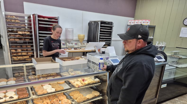 Tyler Burt picks out a box of donuts at Milton's Donuts in Middletown. Burt said the prices keep him coming back. MICHAEL KURTZ / STAFF