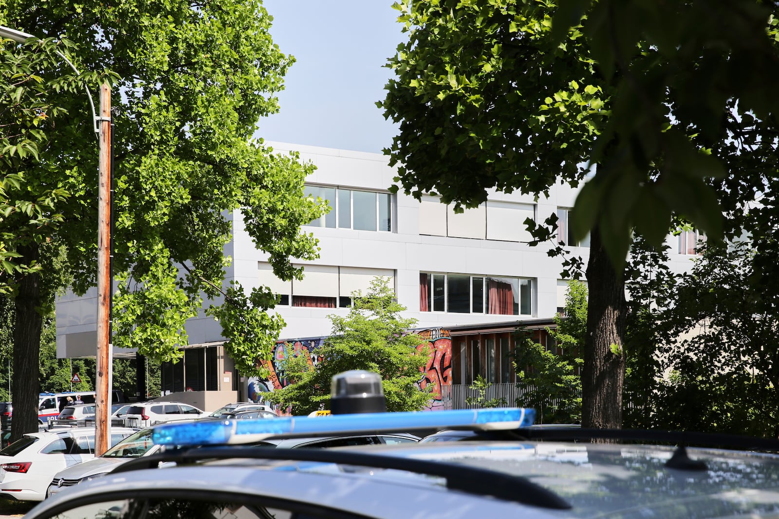 A police car stand in front of a school building after shooting at the school in Graz, Austria, Tuesday, June 10, 2025. (AP Photo/Heinz-Peter Bader)