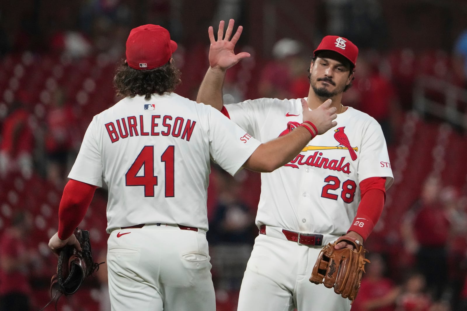 St. Louis Cardinals' Nolan Arenado (28) and Alec Burleson celebrate a victory over the Cincinnati Reds following a baseball game Tuesday, Sept. 16, 2025, in St. Louis. (AP Photo/Jeff Roberson)