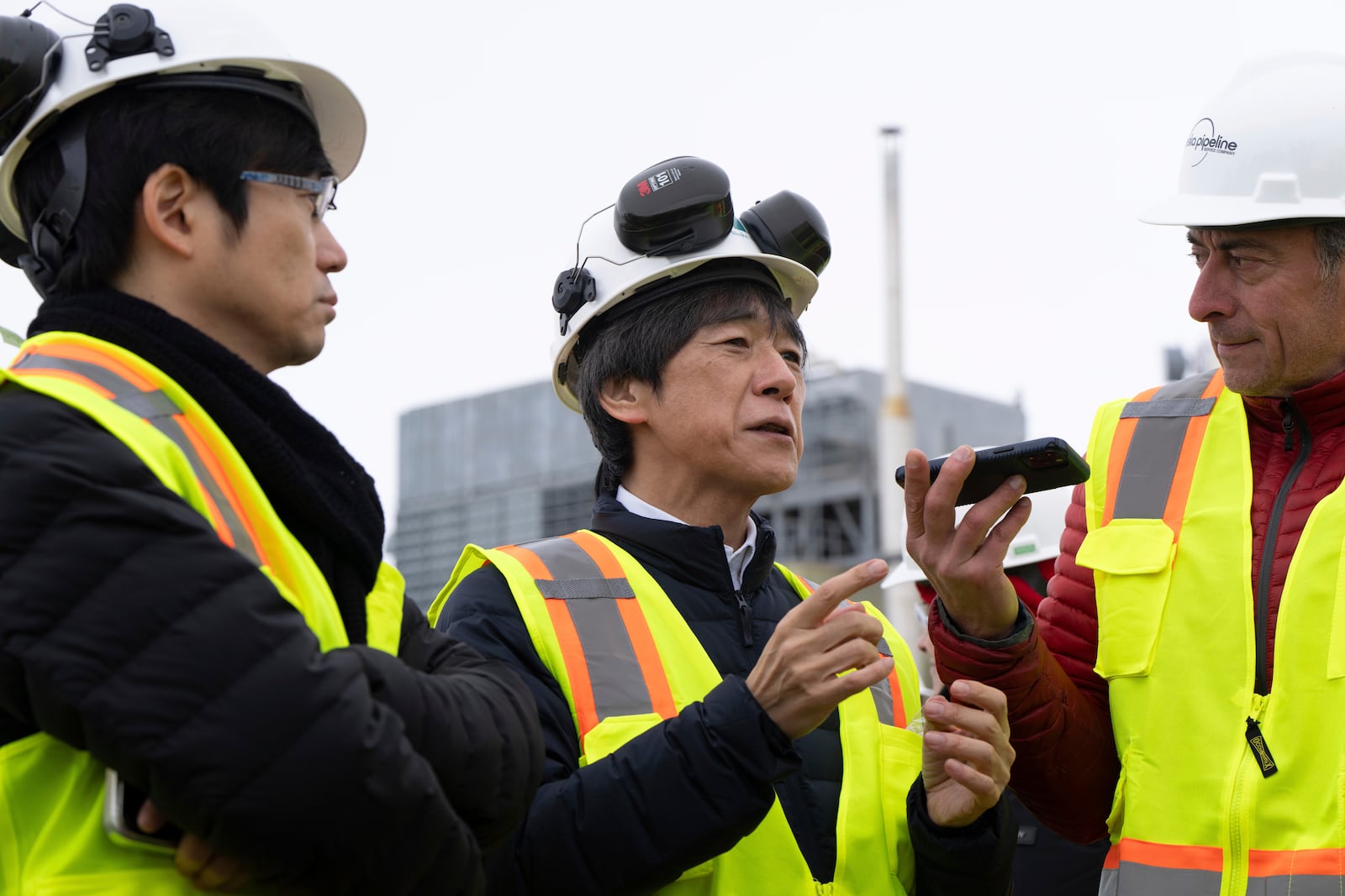 Matsuo Takehiko, center, Japan's Vice Minister for International Affairs at the Ministry of Economy, Trade and Industry (METI), speaks to members of the media before a news conference at the Pump Station 1 on Monday, June 2, 2025, located near Deadhorse, Alaska, on the state's prodigious North Slope. (AP Photo/Jenny Kane)