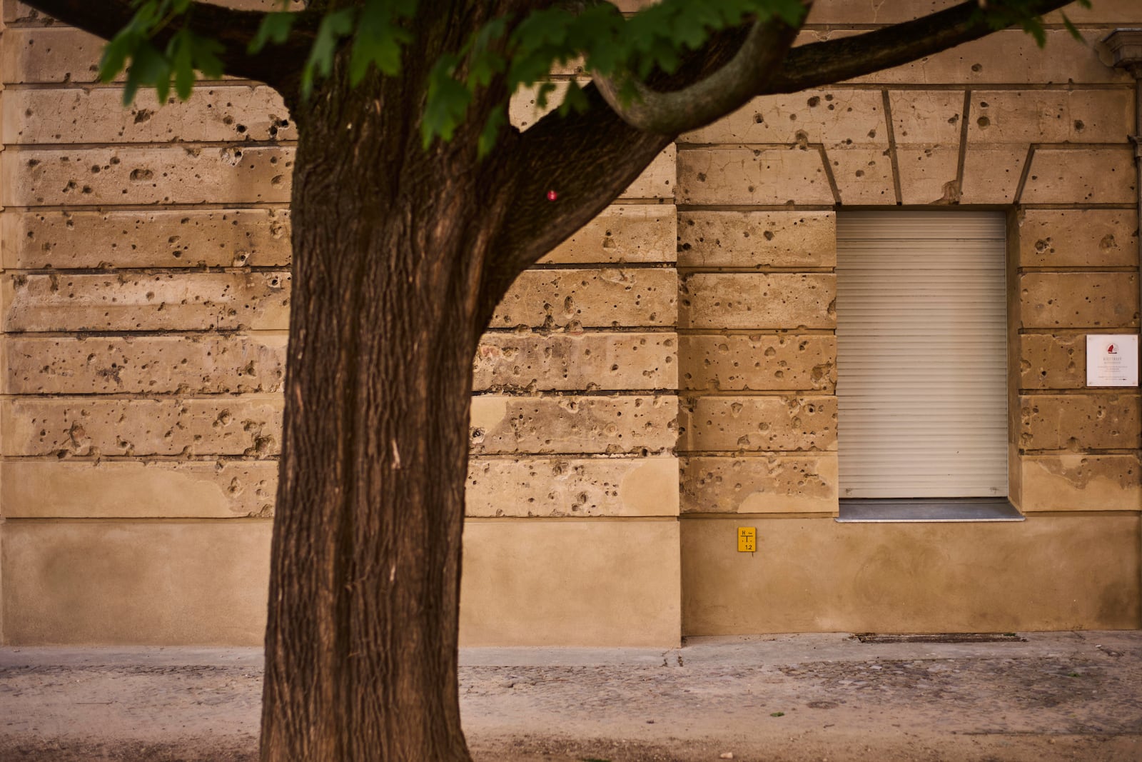 Eighty years after the end of World War II, holes from artillery fire are still visible on the facade of a house in the city center of Berlin, Germany, Friday, May 2, 2025. (AP Photo/Markus Schreiber)