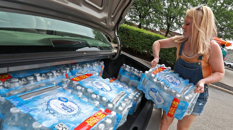 Camaren Sloan, from the Chamber of Greater Springfield, loads cases of donated drinking water into the trunk of her car Wednesday for transport to the tornado victims in the Dayton area. The Chamber posted on their Facebook page that they were taking donations and have gotten dozens of cases donated. BILL LACKEY/STAFF