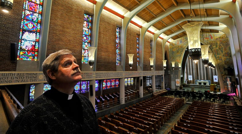 Andy Tune, pastor at Wittenberg University, looks over the stained glass windows in the university’s Weaver Chapel. Bill Lackey/Staff