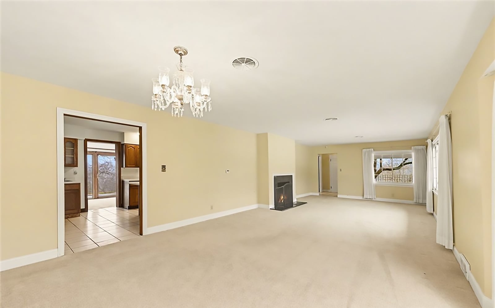 the living room and dining room have updated neutral carpeting. The living room has a woodburning fireplace and the dining room has a bay window and decorative chandelier. CONTRIBUTED