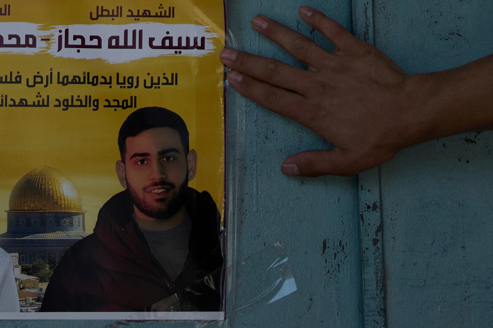 A memorial poster showing Palestinian-American Sayfollah Musallet, who was beaten to death by Israeli settlers, is displayed outside of a bakery in the West Bank town of Al Mazra as-Sharqiya, Monday, July 21, 2025. (AP Photo/Maya Alleruzzo)