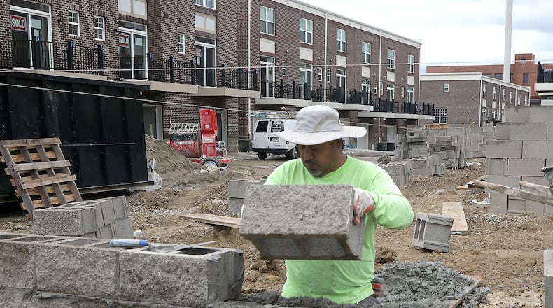A construction crew works on the foundation for the final set of townhomes in the Center Street Townes project in downtown Springfield Tuesday, August 30, 2022. The county saw an estimated 1,000 more people employed last month when compared to previous trends. BILL LACKEY/STAFF