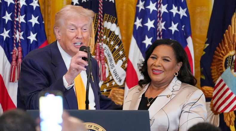 President Donald Trump speaks as White House pardon czar Alice Johnson listens during a Black History Month event in the East Room of the White House, Wednesday, Feb. 18, 2026, in Washington. (AP Photo/Nathan Howard)