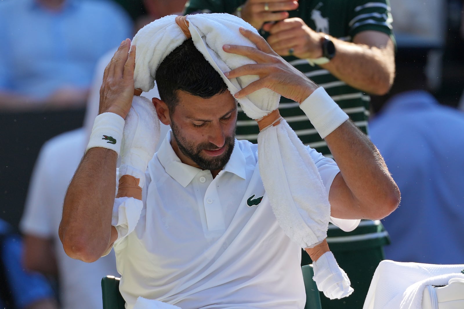 Serbia's Novak Djokovic tries to keep cool during a change of ends break against Italy's Jannik Sinner in a men's singles semifinal at the Wimbledon Tennis Championships in London, Friday, July 11, 2025. (AP Photo/Kin Cheung)
