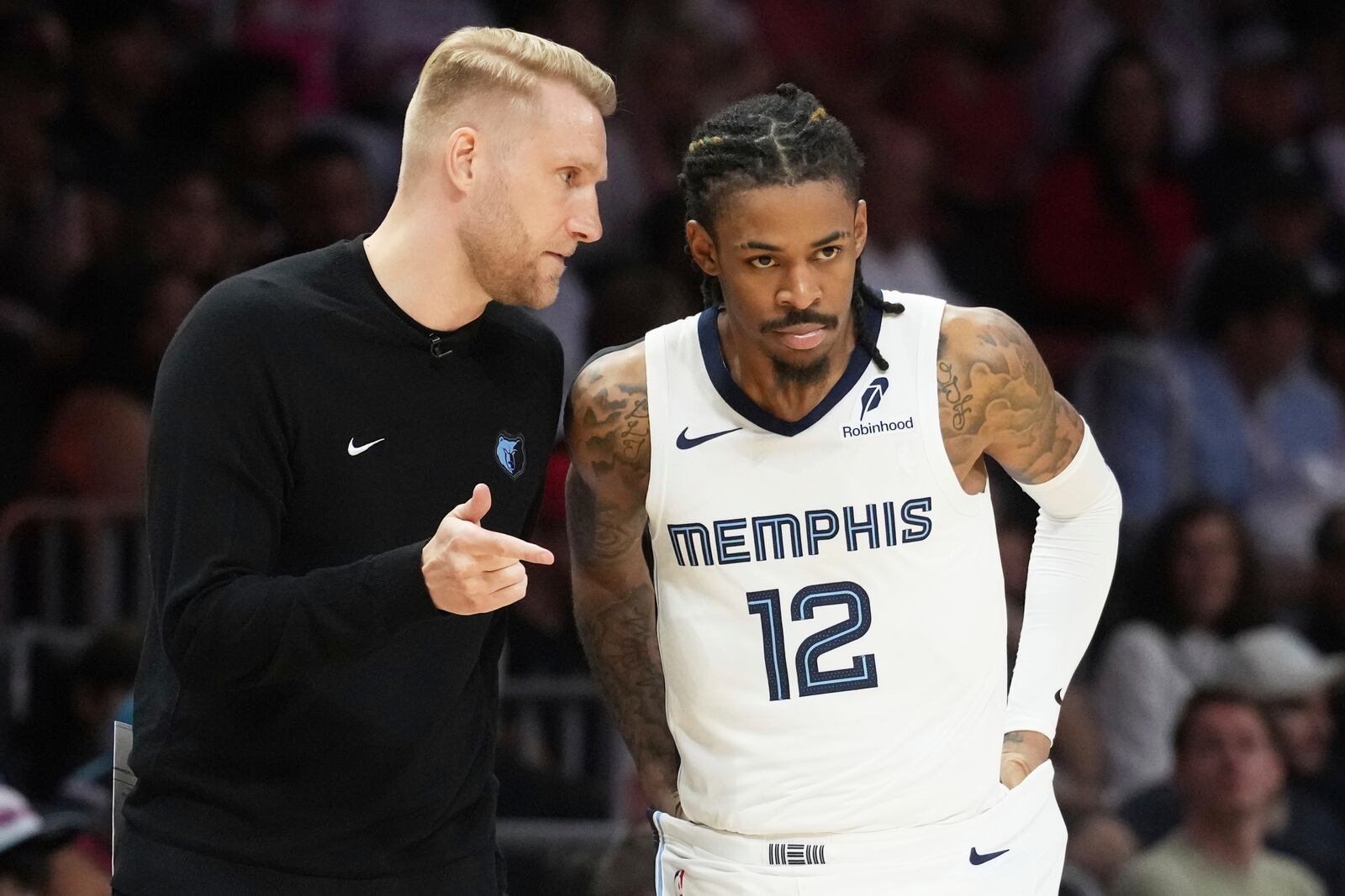 Memphis Grizzlies interim head coach Tuomas Lisalo talks to guard Ja Morant (12) during the second half of an NBA basketball game, Thursday, April 3, 2025, in Miami. (AP Photo/Marta Lavandier)