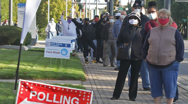 Clark County residents wait in line outside Clark State's Turner Studio Theater to vote early Tuesday. BILL LACKEY/STAFF