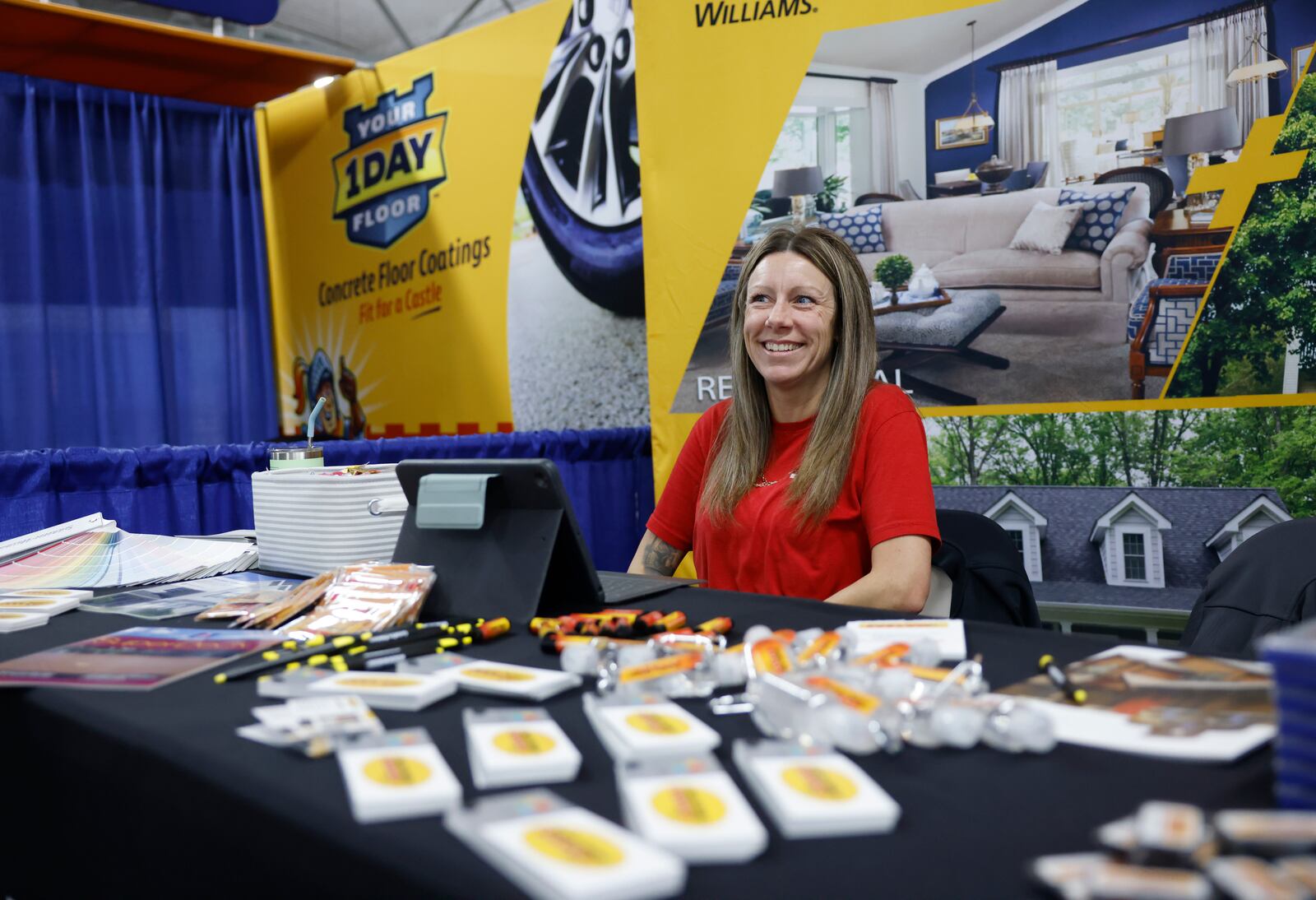 Jessica Behnken, residential sales associate of CertaPro Painters, of Xenia, talks to a customer after they buy a product from her booth at the Clark County Home and Garden Show. JOSEPH COOKE/STAFF