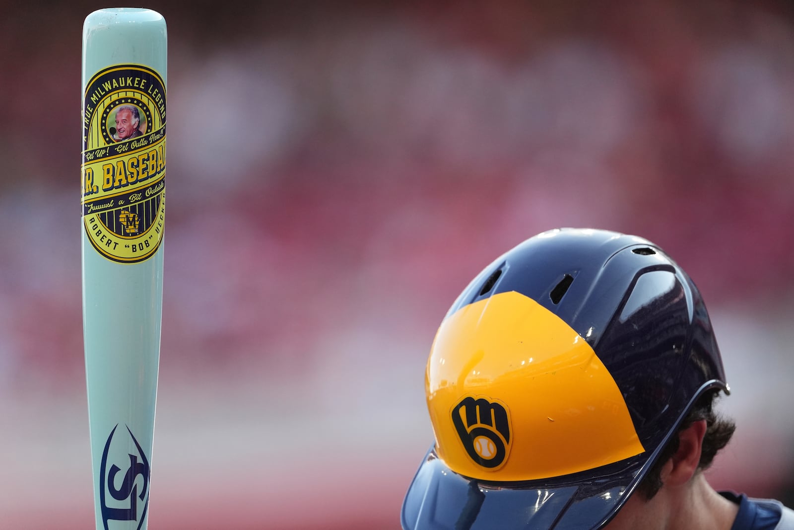 Milwaukee Brewers' Christian Yelich stands in the on-deck circle, holding a custom bat for Players' Weekend, in the first inning of a baseball game against the Cincinnati Reds, Friday, Aug. 15, 2025, in Cincinnati. (AP Photo/Kareem Elgazzar)