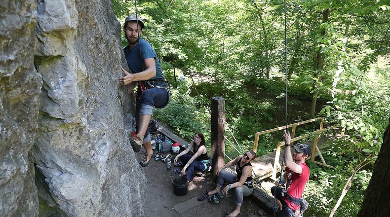 Jackson Pope works his way up a limestone cliff as he and his friends, from left, Emily Andrews, Mallory Hutton and Michael Barr rock climb at Mad River Gorge Tuesday. BILL LACKEY/STAFF