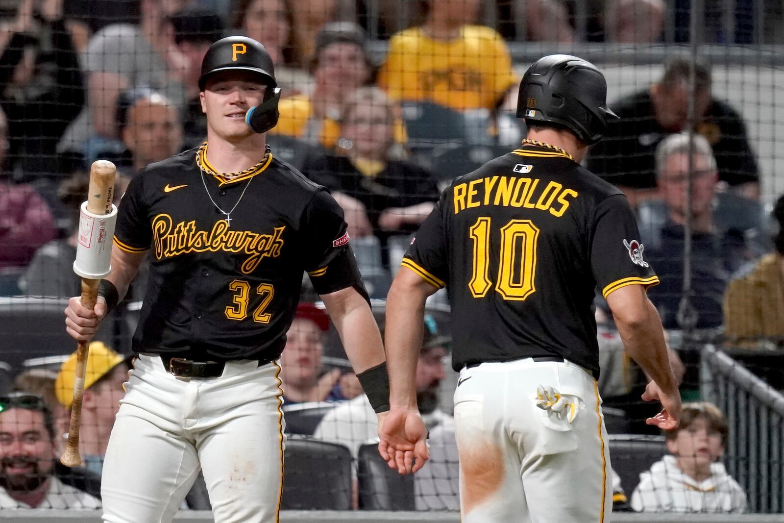Pittsburgh Pirates' Bryan Reynolds (10) is greeted by Henry Davis (32) after scoring during the eighth inning of a baseball game against the Washington Nationals, Monday, April 14, 2025, in Pittsburgh. (AP Photo/Matt Freed)