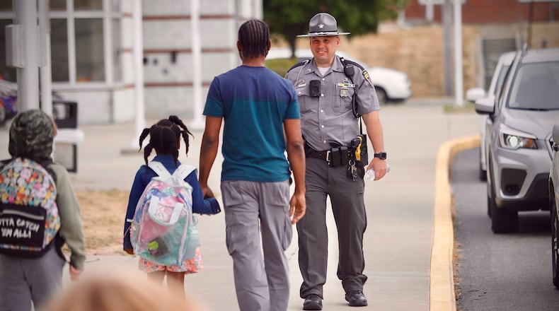 Sgt. Scott Schweinfuth of the Ohio State Highway Patrol greets parents and students Tuesday, September 17, 2024 at Snowhill Elementary in Springfield. MARSHALL GORBY\STAFF