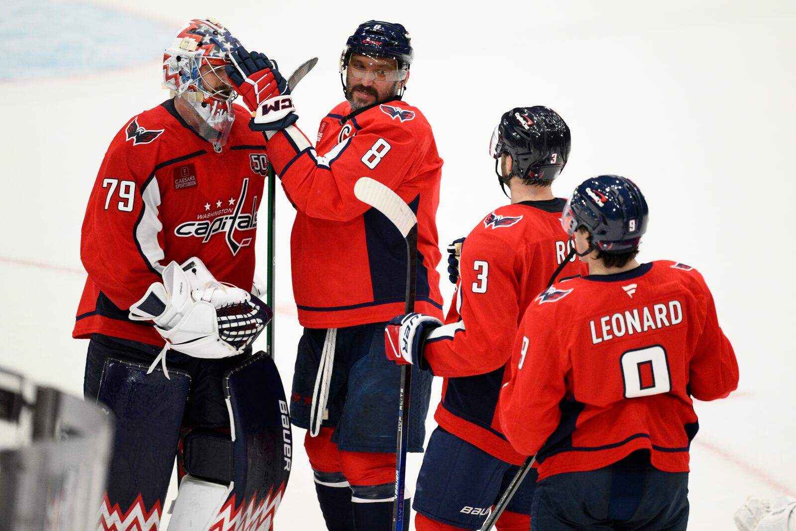 Washington Capitals left wing Alex Ovechkin (8) celebrates with goaltender Charlie Lindgren (79), defenseman Matt Roy (3) and right wing Ryan Leonard (9) after an NHL hockey game against the Carolina Hurricanes, Thursday, April 10, 2025, in Washington. (AP Photo/Nick Wass)