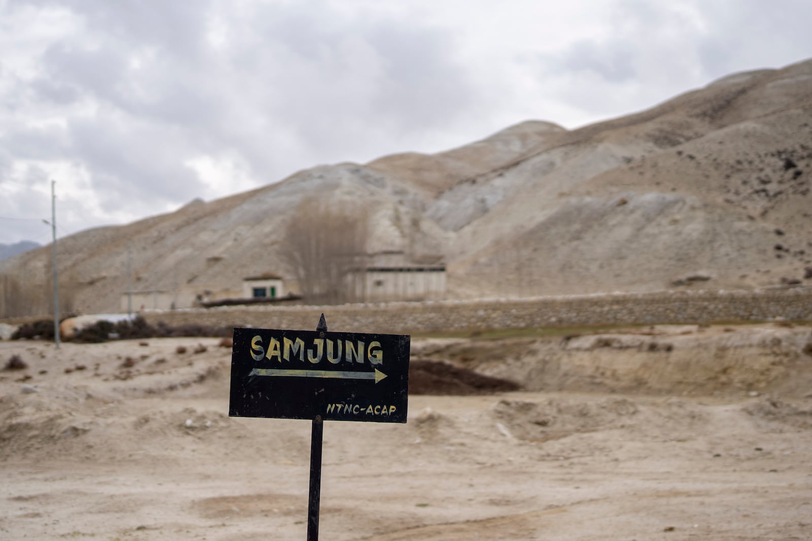 A signboard points the way to the newly relocated settlement of the abandoned Samjung village in the Mustang region, 462 kilometers (288 miles) west of Kathmandu, Nepal, Saturday, April 19, 2025. (AP Photo/Niranjan Shrestha)