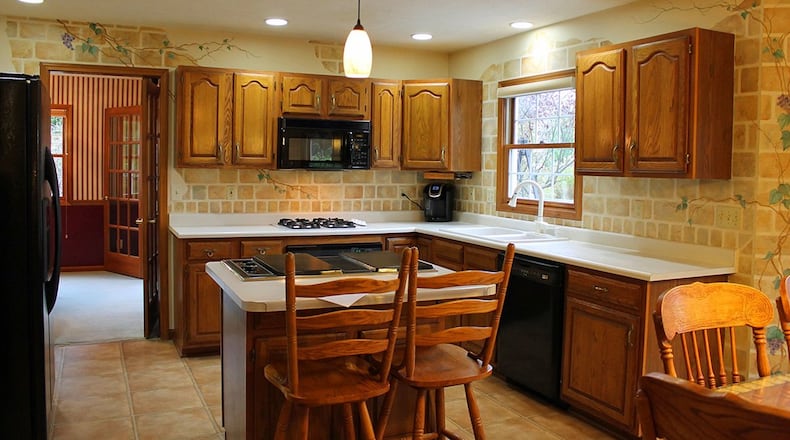 The kitchen boasts a center island and plenty of wood cabinetry.